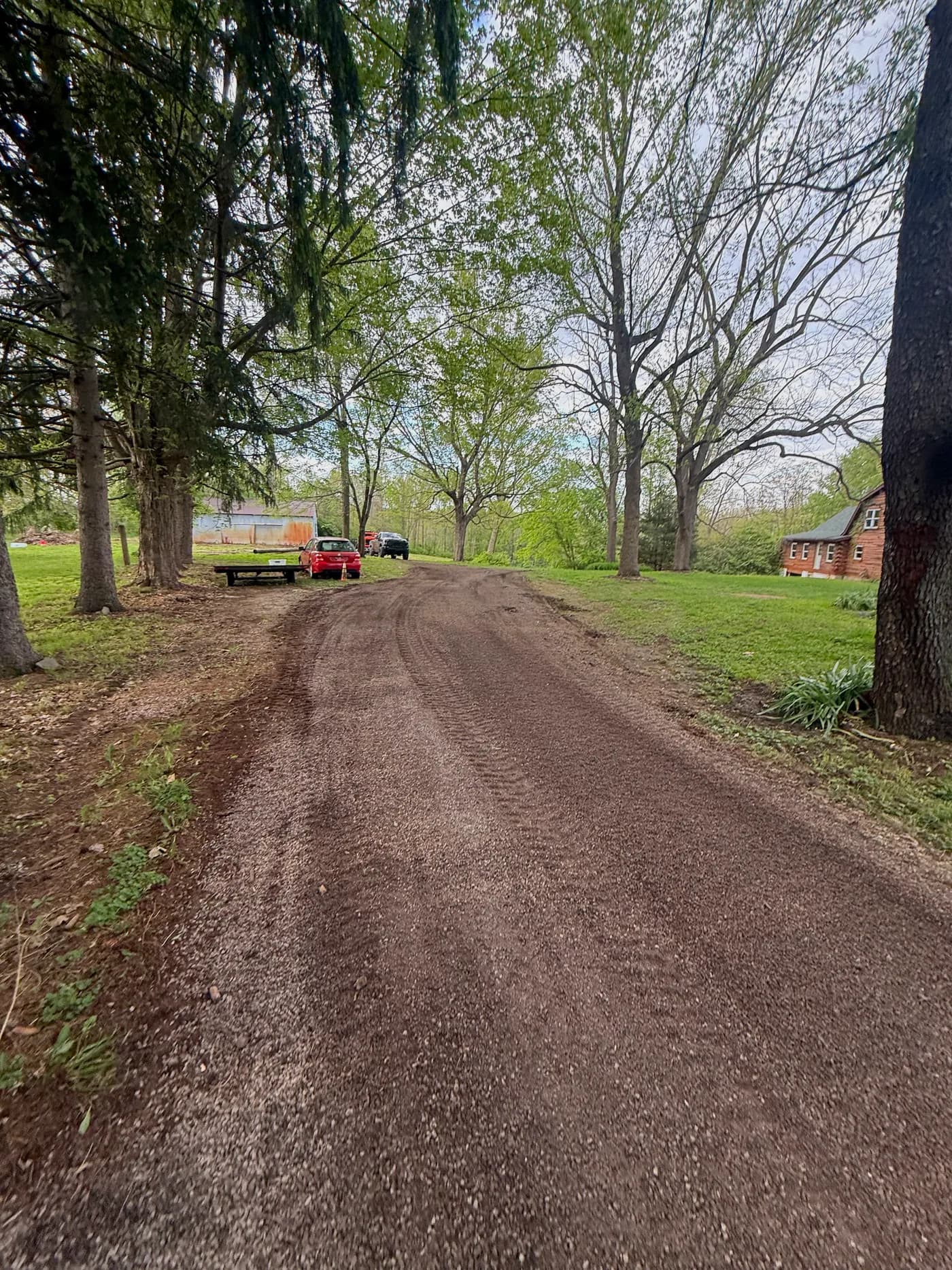 Skid steer grading gravel on a residential drive