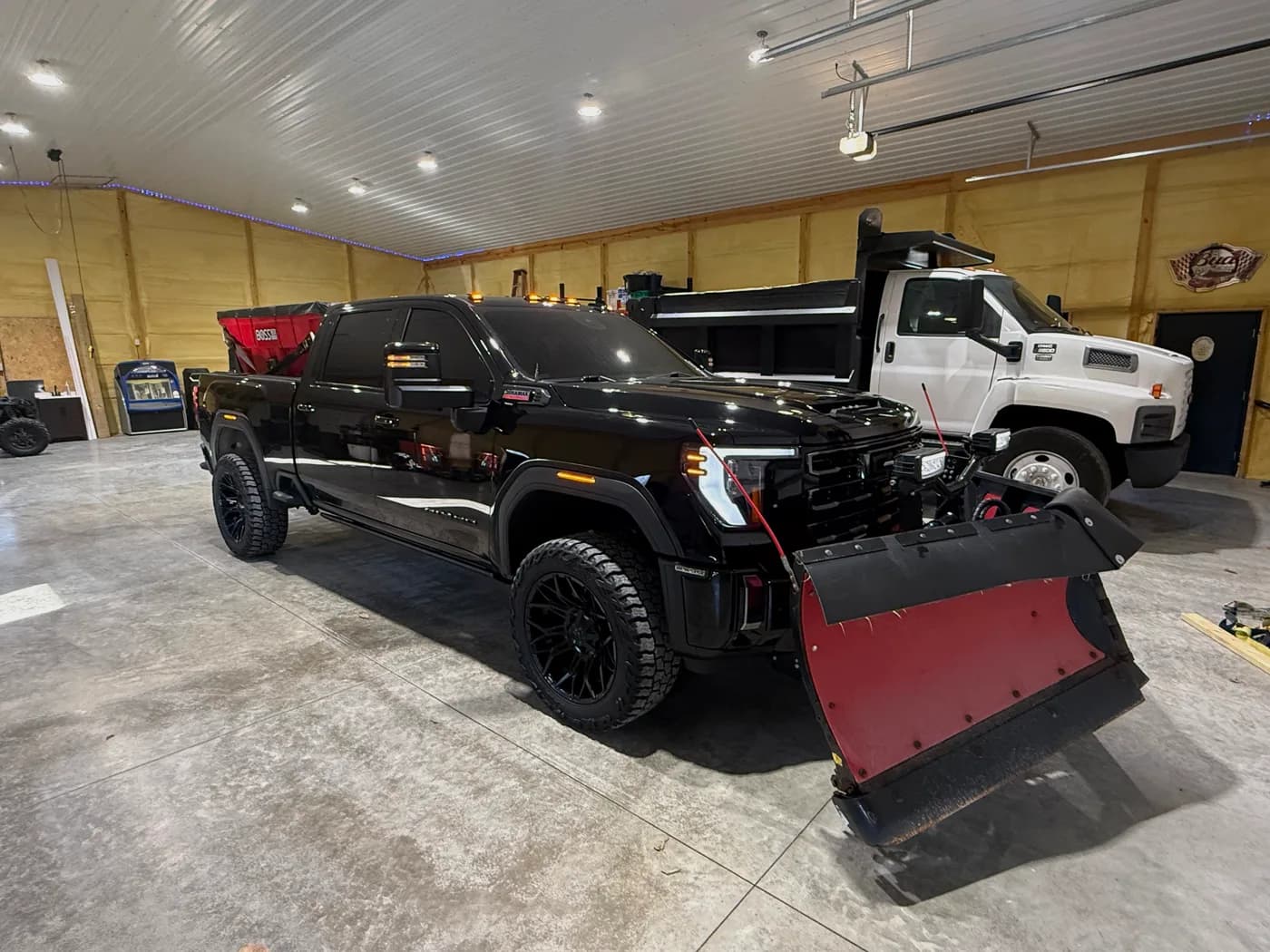Outdoor Muscle plow truck and skid steer staged in the shop